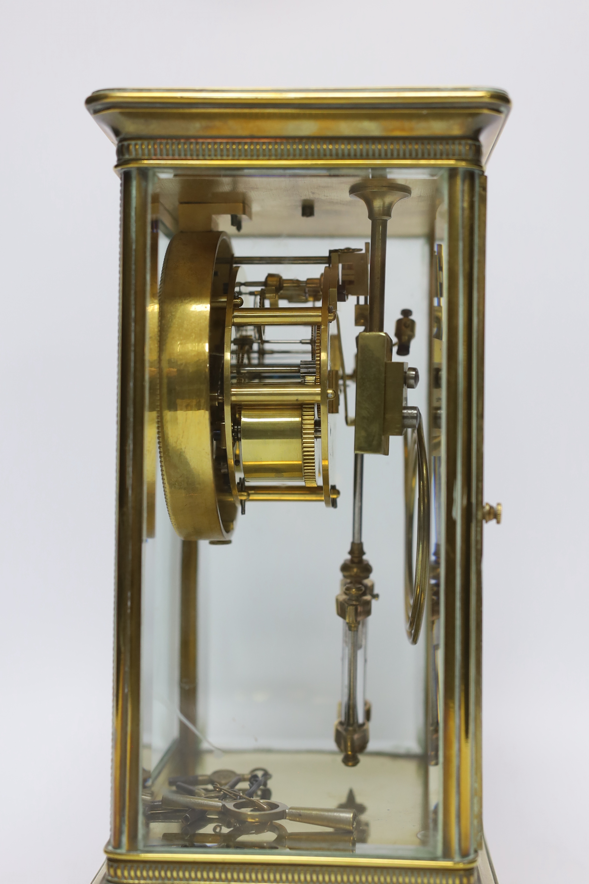 A late 19th century four glass brass clock with key and pendulum, 27cm